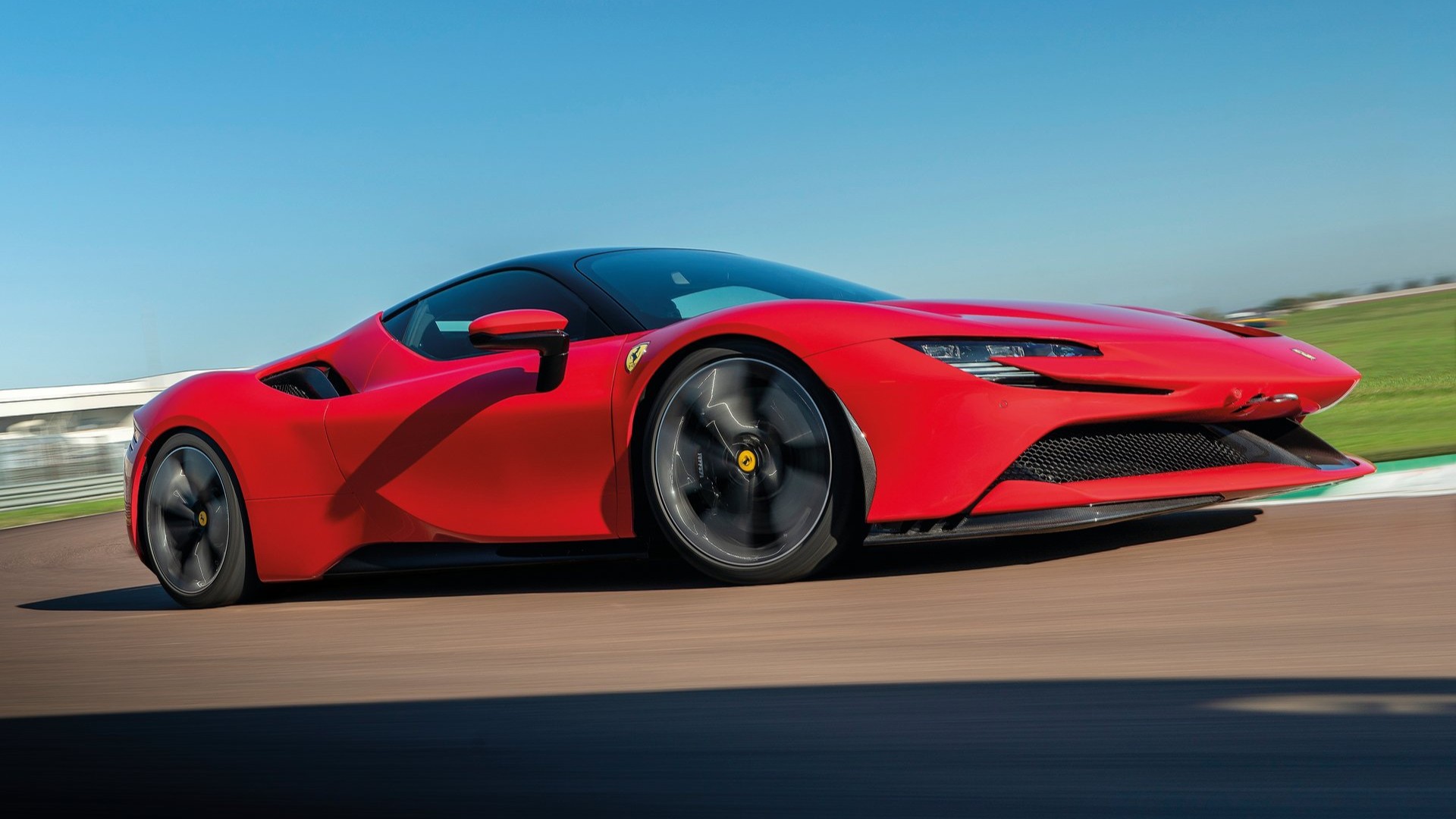 Dynamic side shot of a red Ferrari SF90 Stradale on a race track
