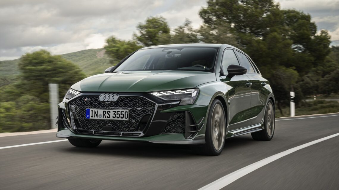 A dynamic shot, covering the front three-quarters, of a Malachite green Audi RS 3 Sportback competition limited