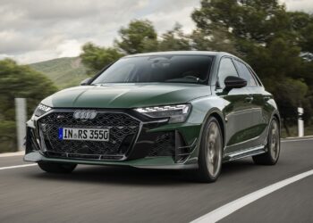 A dynamic shot, covering the front three-quarters, of a Malachite green Audi RS 3 Sportback competition limited