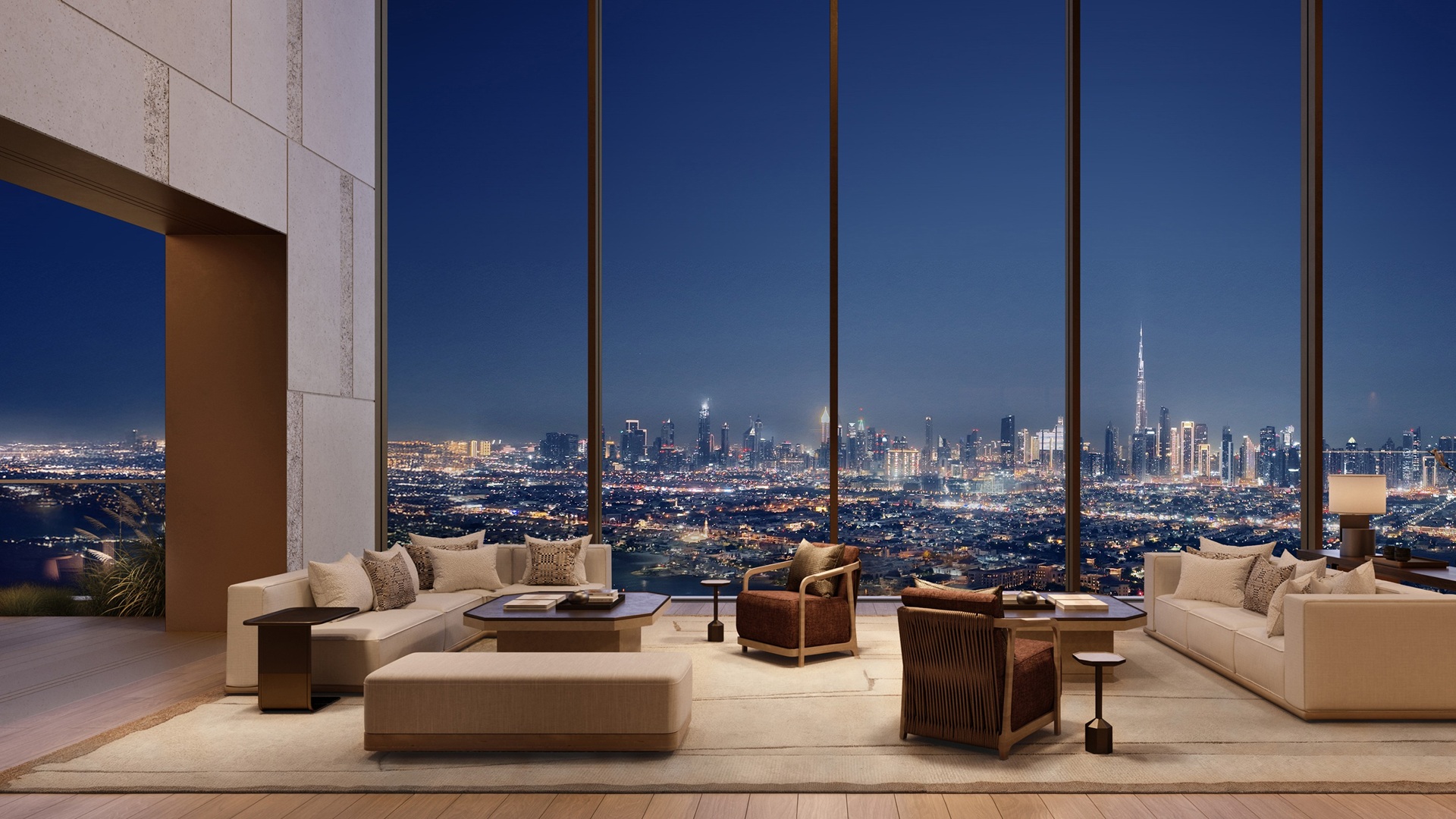 The living room of the five-bedroom residence, with a night time view of the city's skyline, at Aman Dubai