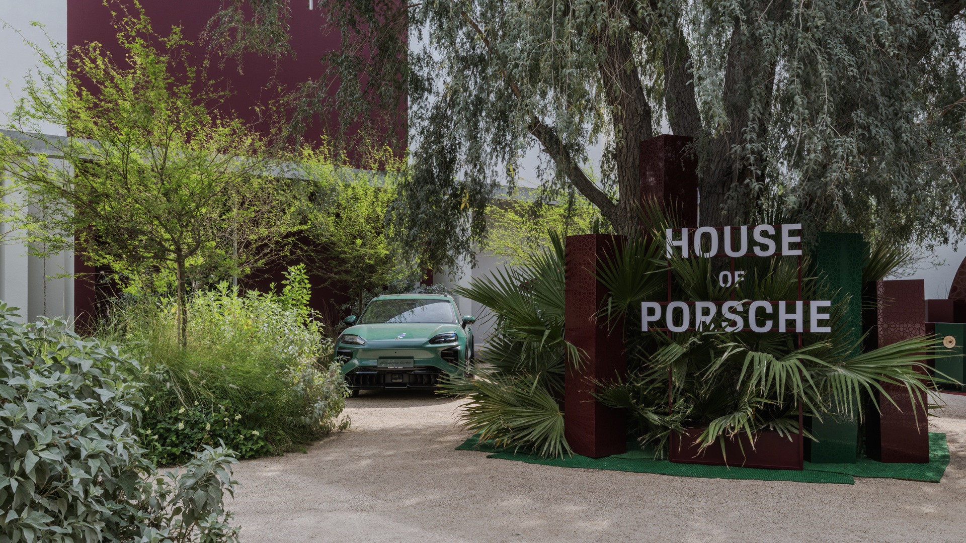 An exterior shot of House of Porsche at Paus Club Dubai with a Green Cayenne Electric