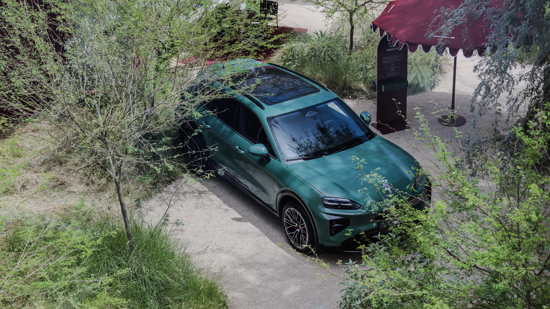 An exterior shot of House of Porsche at Paus Club Dubai with a Green Cayenne Electric