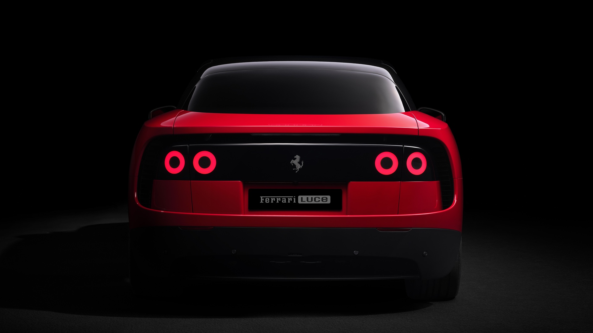 A studio shot of the Ferrari Luce in Rosso Fiammante, taken from the rear with brake lights on