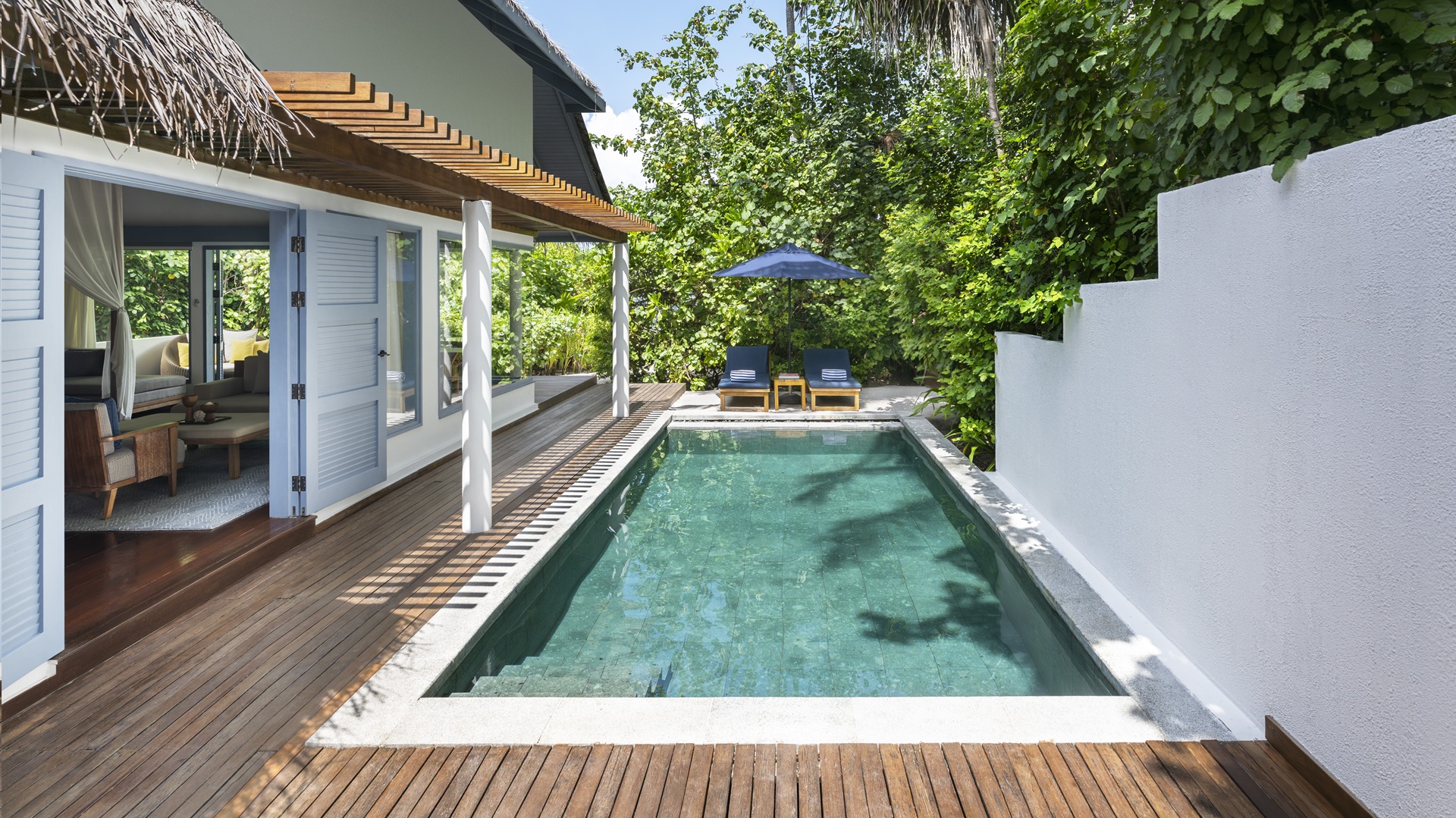 The pool area with one of the villas, overlooking the beach, at The Halcyon Private Isles Maldives