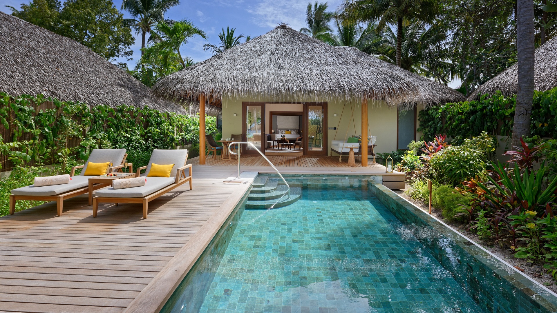 The swimming pool and rest area with Baros Residence, part of Baros Maldives Villas