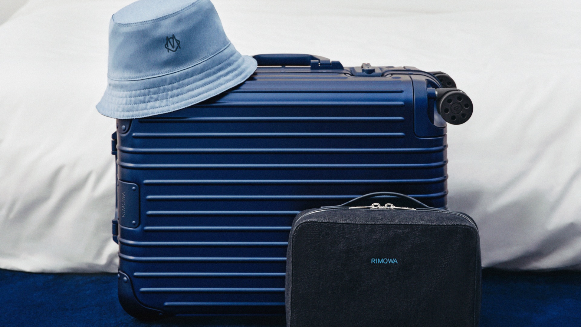 RIMOWA Original Ink Blue launched - image shows the bucket hat, a suitcase and a packing cube
