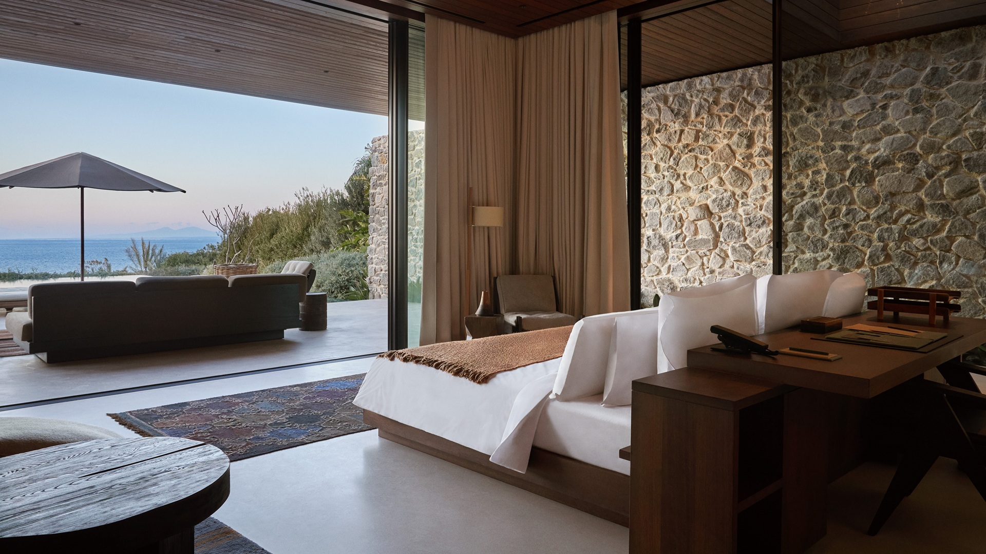 Maxx Royal Bodrum Villas: An image of the bedroom, with a bed, a sitting area and the view outside.