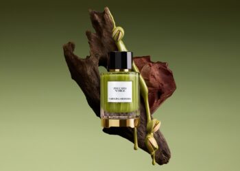 Carolina Herrera Peccato Nobile: A bottle of the scent with the elements of its key notes in the background