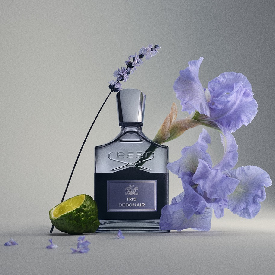 Creed Iris Debonair: A static image of the scent's bottle surrounded by the elements that deliver its key notes